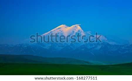 Elbrus mountain lit by the rays of the rising sun in the early morning