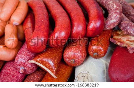 Many uncooked smoked sausages lying on a counter in the market