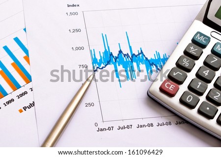 financial performance chart with calculator and pen