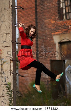 A young girl hanging on a ladder