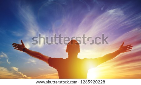 Person on background sunrise. Bright solar glow and sky