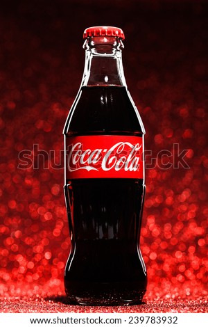 ST. PETERSBURG, RUSSIA - DECEMBER 8, 2014: Classic bottle Of Coca-Cola on red glitter background