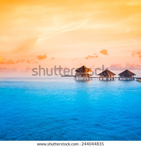 Sunset on Maldives island, water villas resort