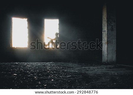 Male silhouette in window, lit by dramatic sunlight.