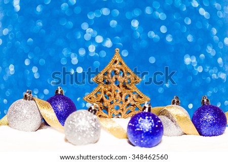 christmas tree and candy in snow on blue glitter background. studio shot