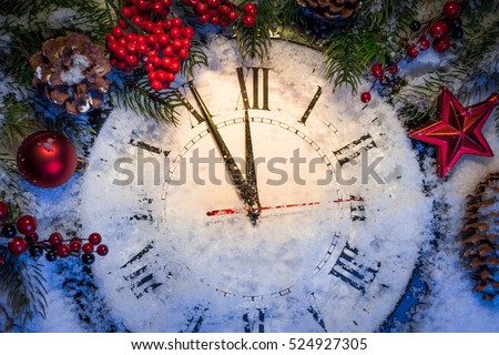 Christmas clock with winter decoration on snow. Happy new year concept