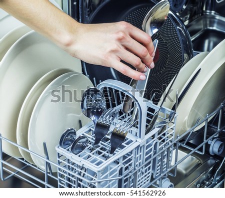 Unloading clean dishes from the dishwasher machine