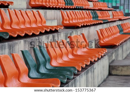 Rows of orange mini-football stadium empty seats