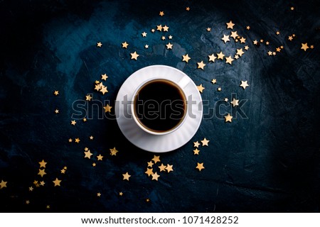 Cup of coffee and stars on a dark blue background. Concept of the Starry sky and Coffee. Flat lay, top view.