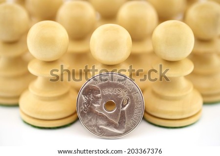 Several chess pieces with an old Spanish coin representing the Republican hope of the Spanish people isolated on white background.