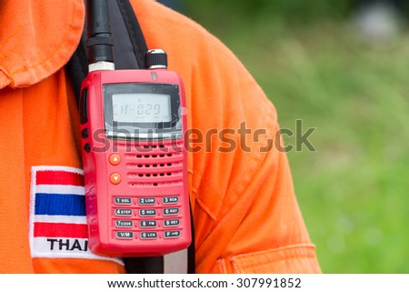 An orange suit of the Fire Rescue unit in Thailand with Thai Flag's badges on the chest with the red radio communication devices