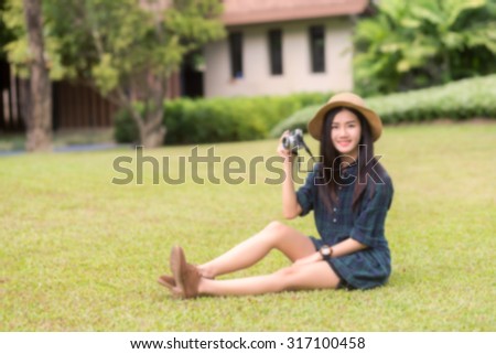 Abstract portrait of a asian girl/women for conceptual use, blur effect applied, shoot outdoor for travelling, holiday, relax  (blurred portrait of girl (asian women) holding on camera in the park)