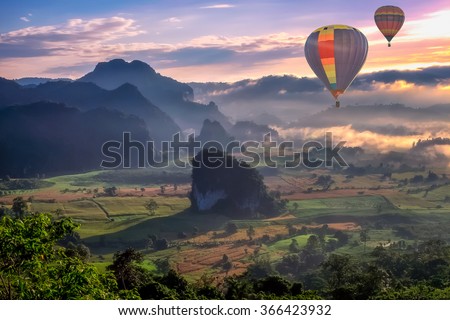 HDR beautiful scenary in the north part of Thailand over the valley of mountain at sun rise beautiful color of mist, hot air balloon flying in sky (selective focus and white balance shifting applied)