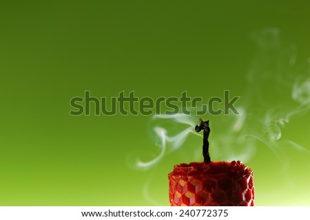 Red smoking beeswax candle