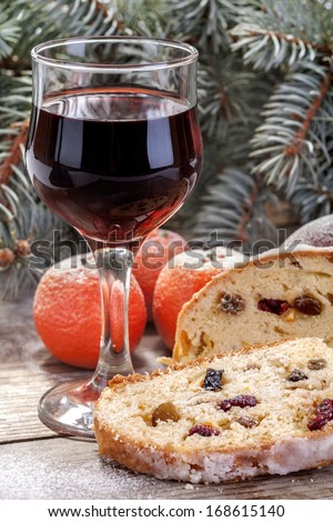 wine glass with fruit cake,  mandarin and apple in winter decor