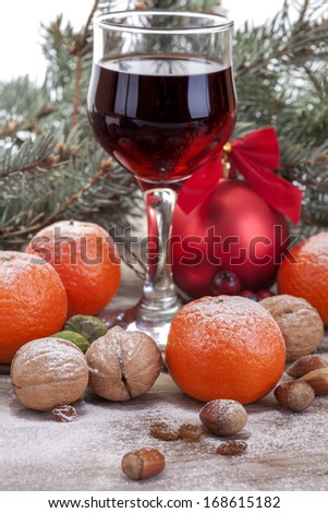 wine glass with mandarin, walnuts, hazelnuts in the winter and New Year decor