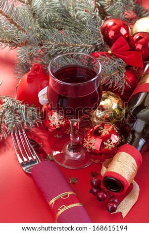 A glass of wine and eating utensils with Christmas and New Year decorations