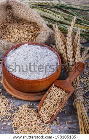 whole grain flour in a bowl and linen bag with a wooden spatula