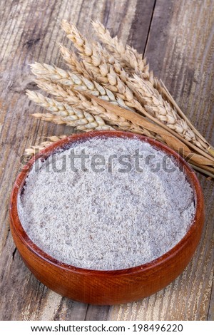 whole grain flour in a bowl on the old rustic table