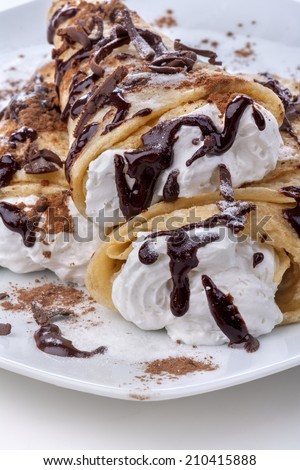 Pancakes with whipped cream topped with chocolate