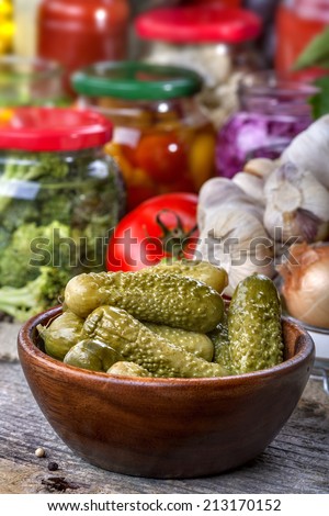 Healthy homemade preserved pickles with canned vegetables in the background