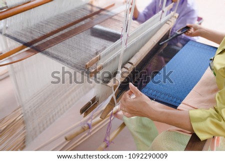 Close up of weaving  loom, cotton on the manual wood loom in Asian traditional culture and woman hand weave lifestyle