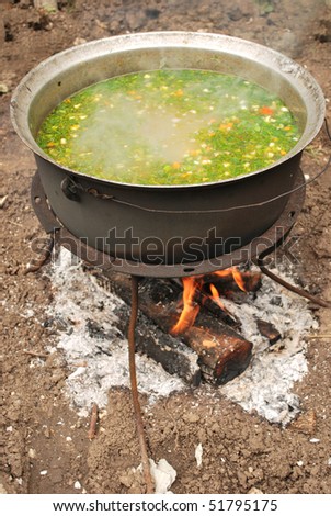 fish soup (with parsley) on fire outside
