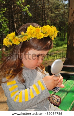 little girl wearing dandelion diadem looking in the mirror