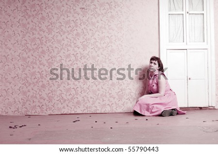 Pink dreams.Attractive middle aged thoughtful woman sitting alone on the floor of empty room.
