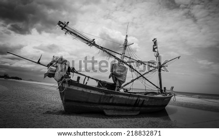 Thai fishing boat on the beach used as a vehicle for finding fish in the sea with sky. Black and white style