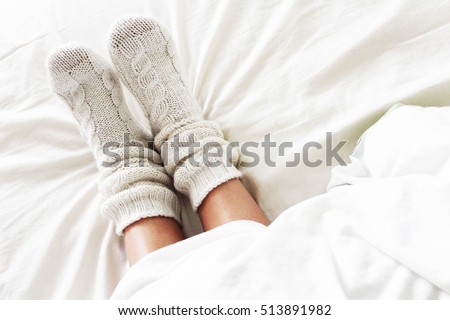 Warm and cozy white socks in the bed