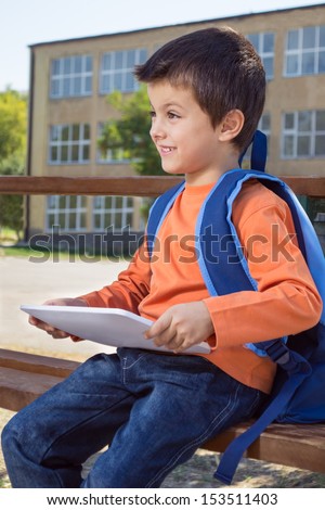 Little boy on his first day at school with tablet