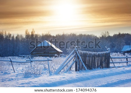 Rural house with a fence in winter