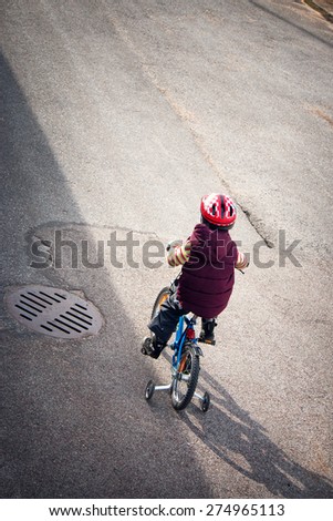 Boy on bike at asphalt road in spring