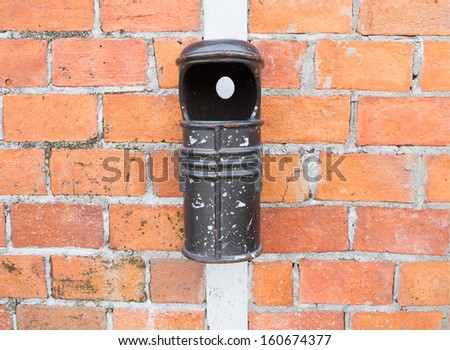 Vintage alloy bin against a brick wall.