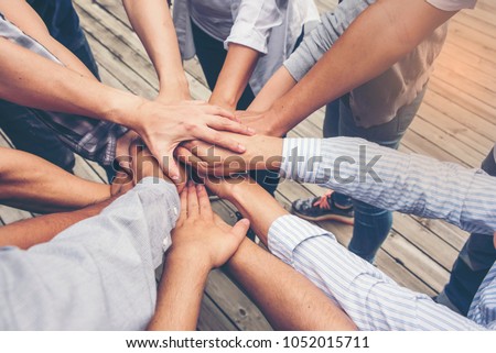 People putting their hands together. Friends with stack of hands showing unity and teamwork.