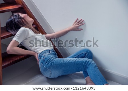 Attractive asian woman accident fall off the stairs and backache Pain or broken backache   in home health insurance concept
