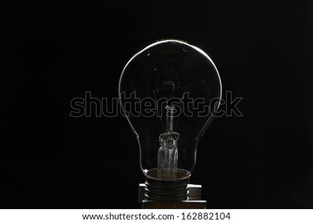 Light bulb turned off over black background