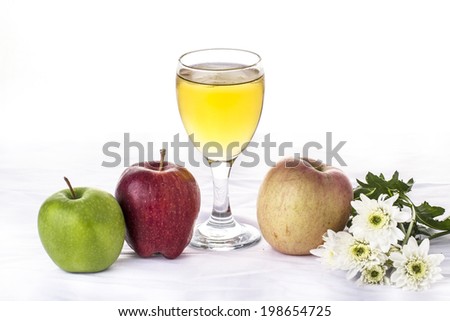 three apples with a glass of apple juice or cider