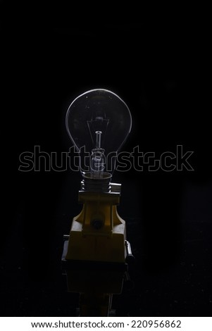 Light bulb turned off over black background