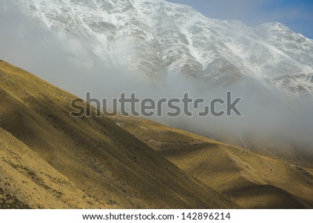 Layer of mountain, ice, snow, cloud, yellow field and meadow hill. Traveling New Zea-land in winter