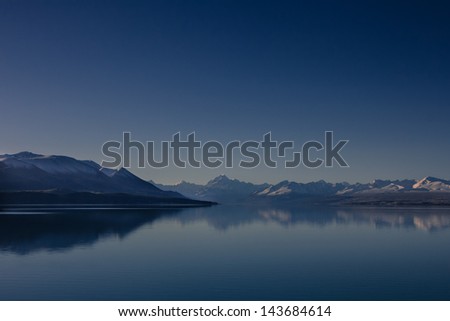 Panorama view of snow, mountain layer, ice and lake with reflection. Traveling New Zea-land in winter