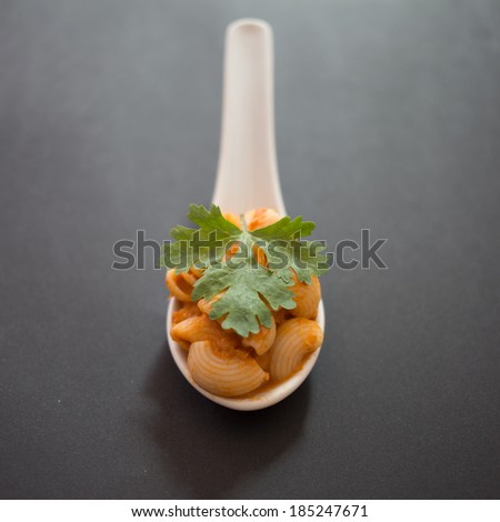Recreation spoon of spicy macaroni with black background and natural lighting