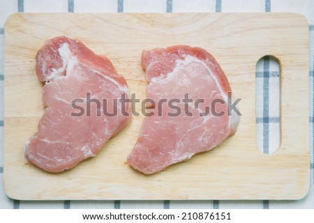 Fresh raw pork on wood chopping board