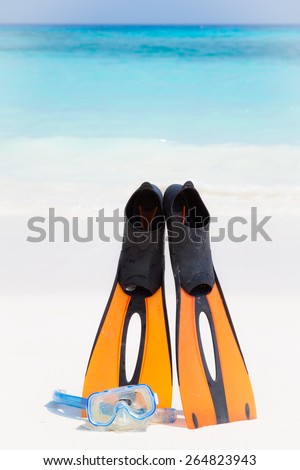 Dive Mask and orange plastic flippers on beach and clear crystal water at Similan island, Phang-nga, Thailand