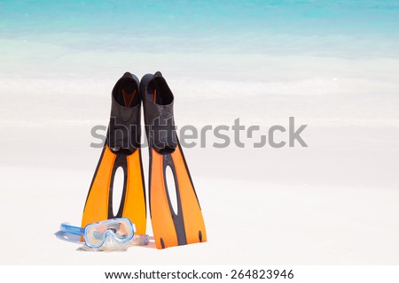 Dive Mask and orange plastic flippers on beach and clear crystal water at Similan island, Phang-nga, Thailand
