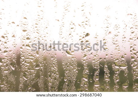 Drops of rain on window in brown background