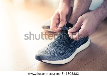 Young runner tying his shoe.