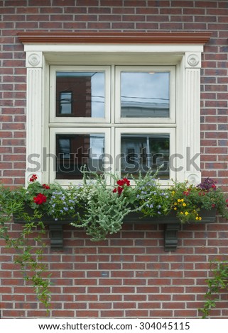 small pale yellow square window on a brick wall