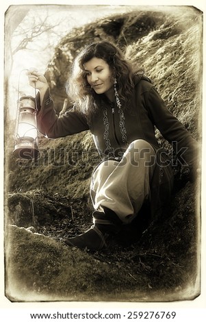 Fantasy beautiful woman with color light lamps in the moss rocks retro black and white